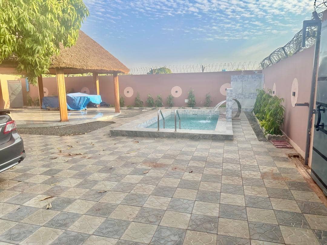 Cour carrelée avec piscine privée et paillote à Koulikoro